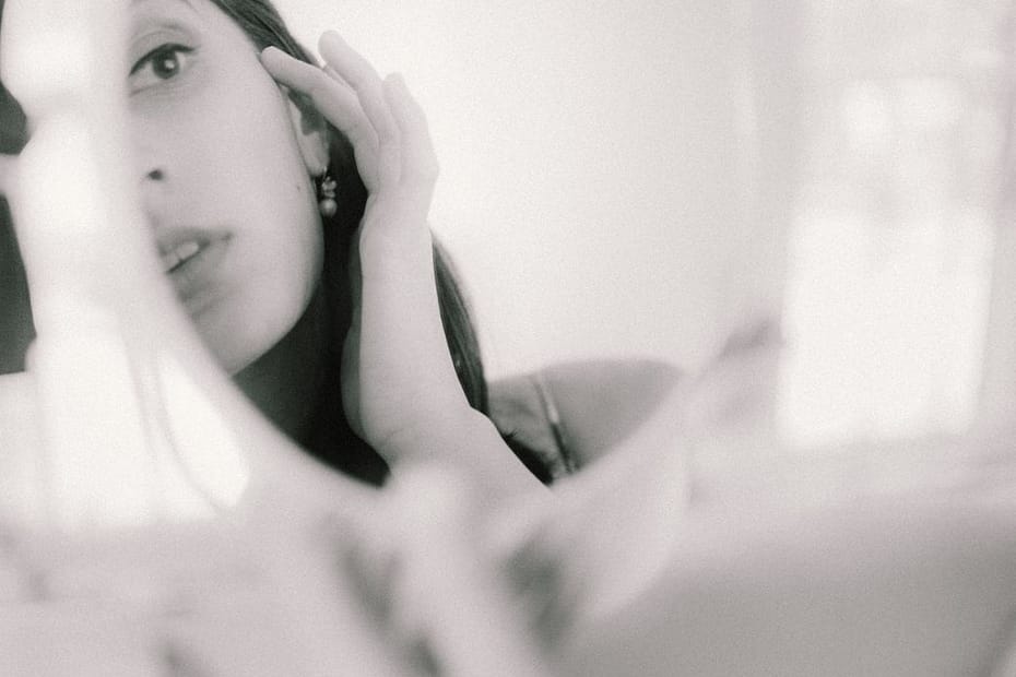 beautiful woman looking at reflection in mirror